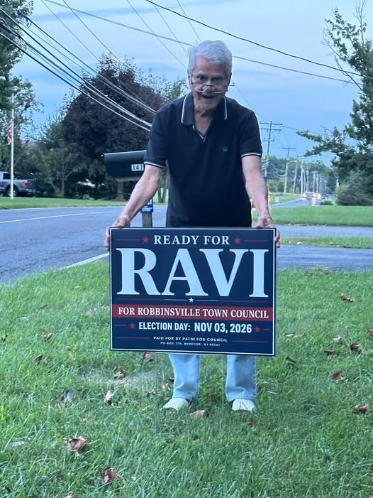 Ravi's father holding the first Ready for Ravi yard sign on a Robbinsville lawn
